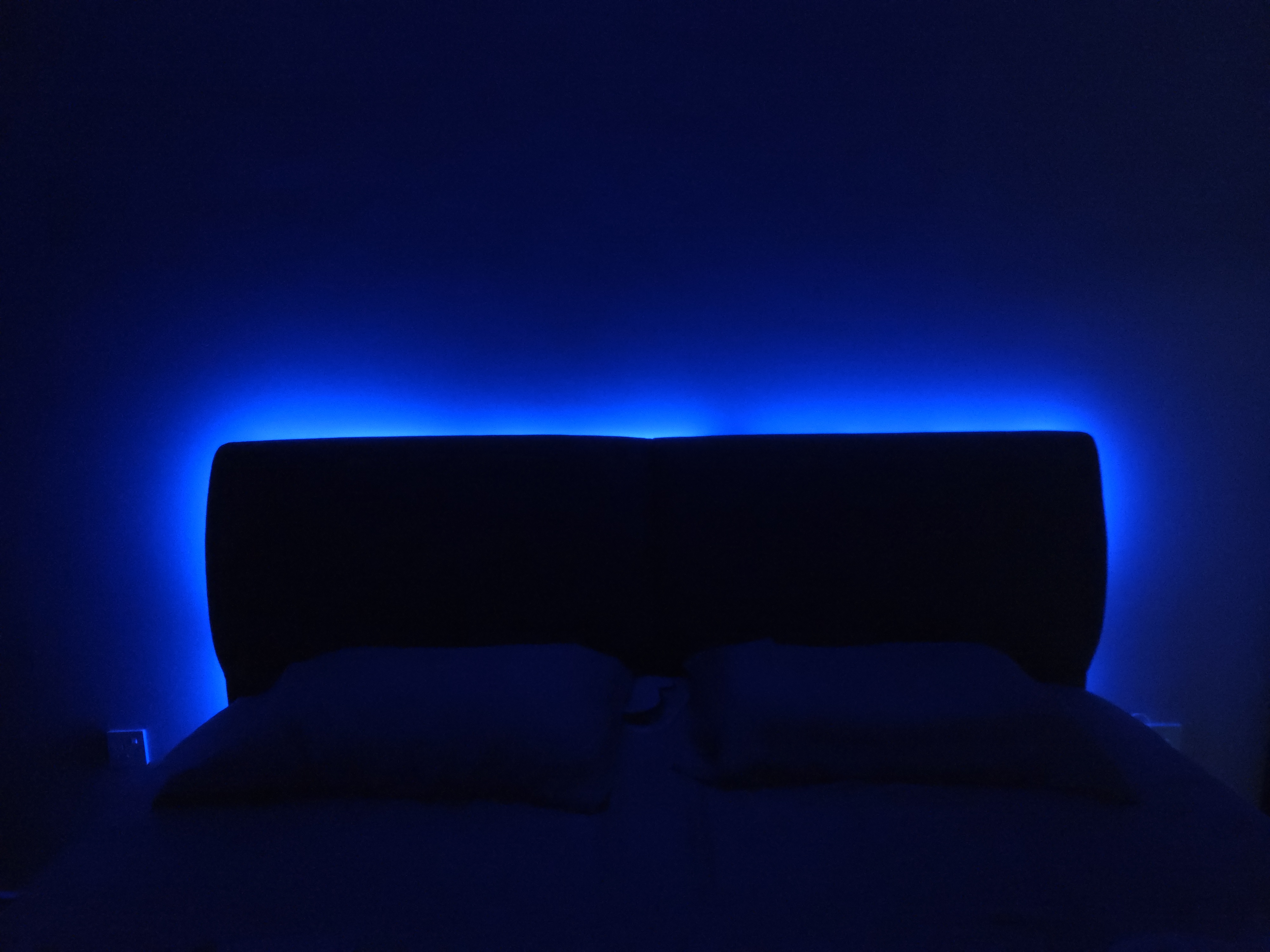 Completed smart lighting project featuring colourful ambient lighting around a bedroom headboard