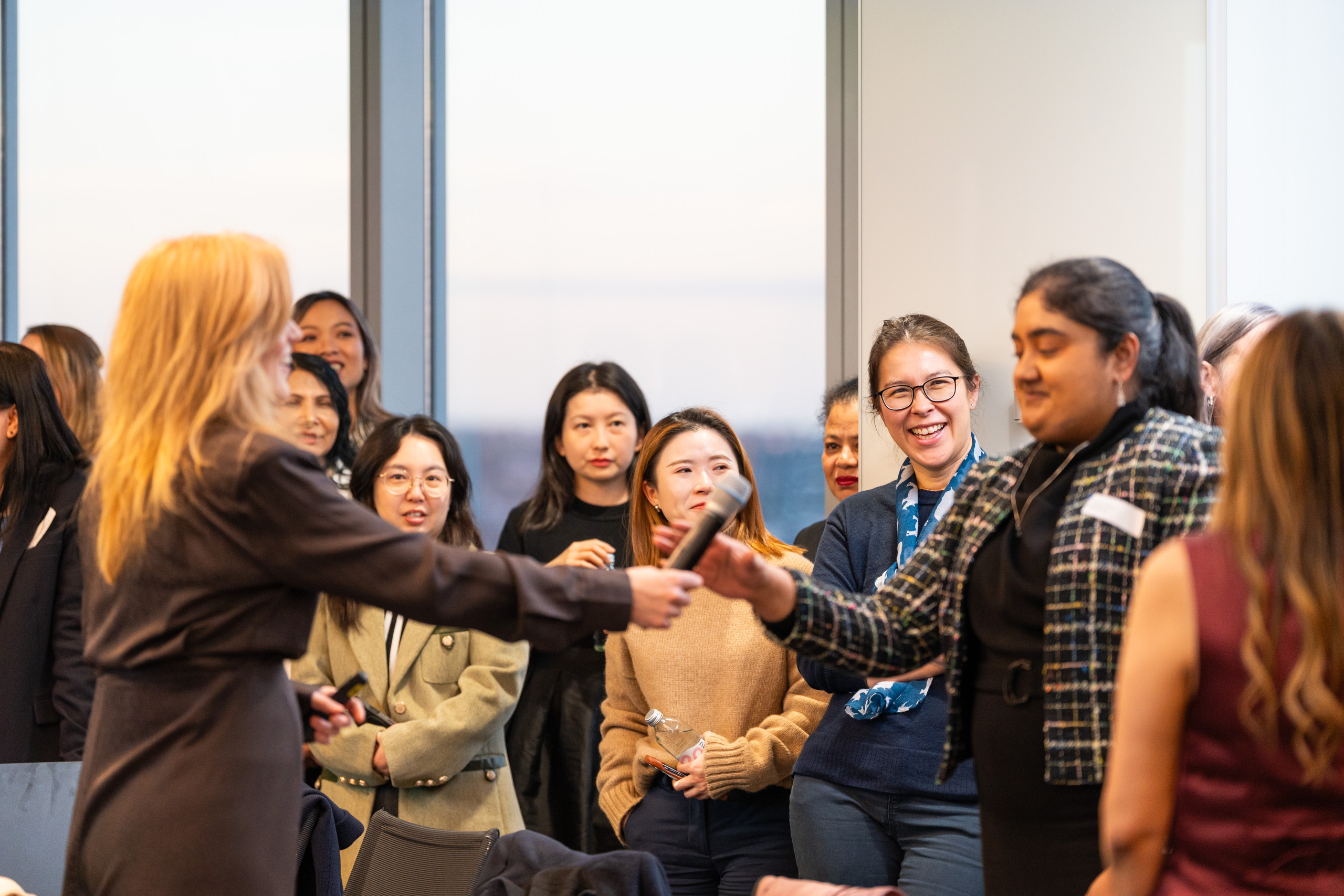 Arabella Macpherson handing the microphone to a participant during a live session