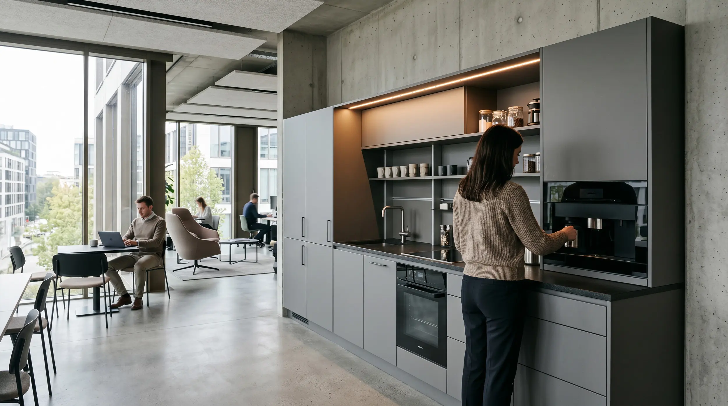 Büroküche mit grauen Fronten und integrierter Kaffeestation im Loft-Office.