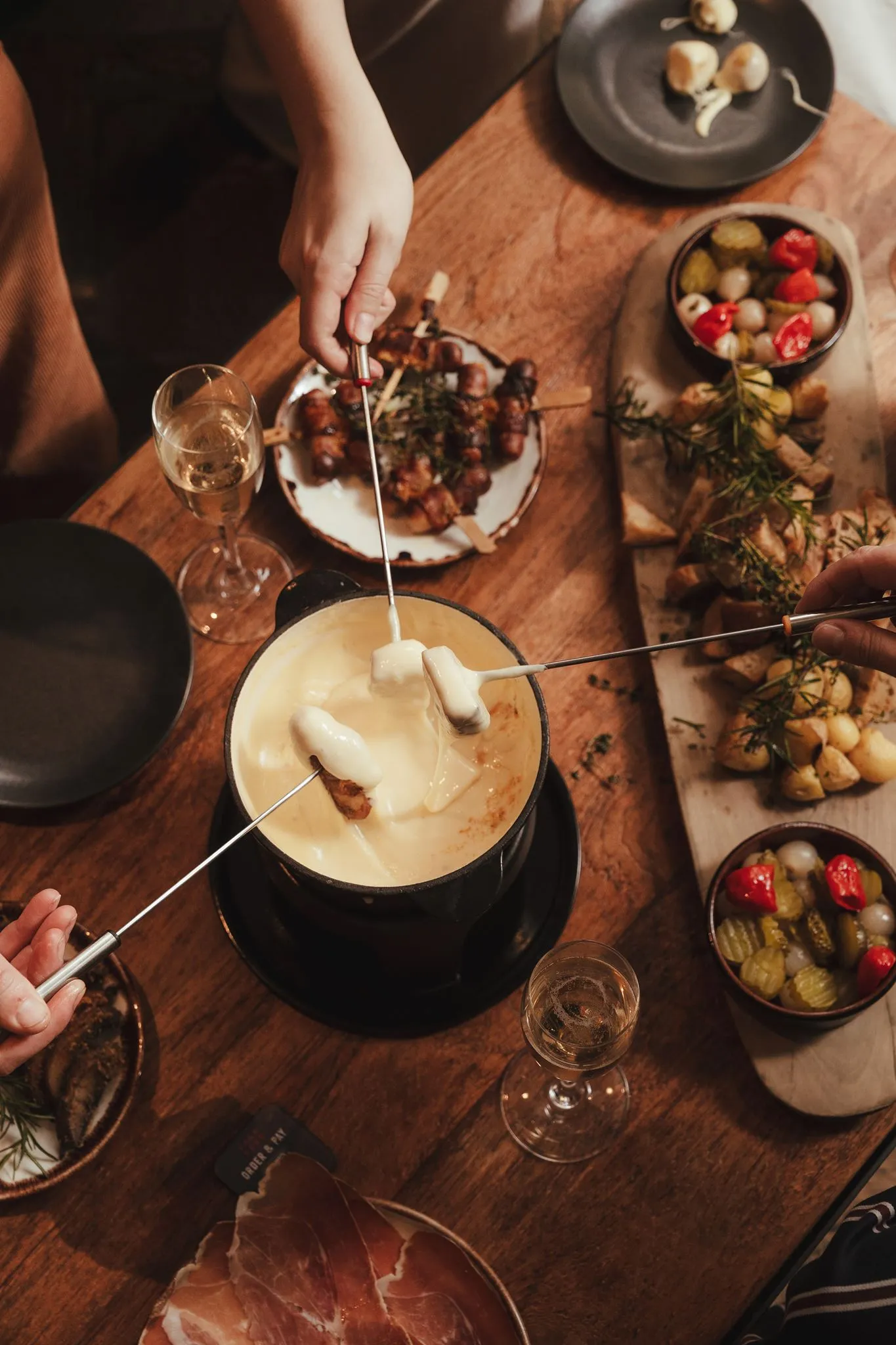 Guests dipping bread into a cheese fondue at Vagabond Monument