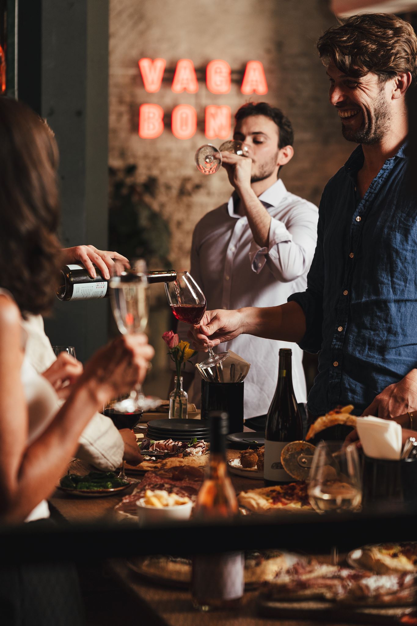 Guests sharing food and wine at the bar