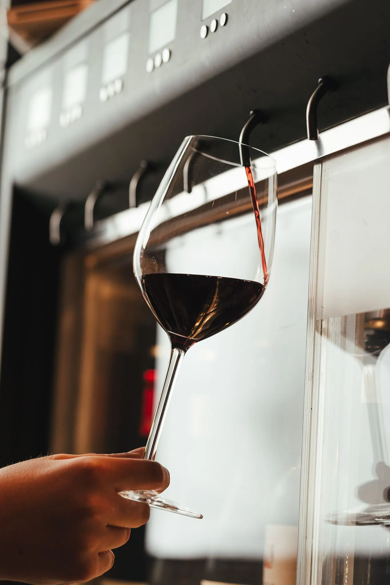 Red wine pouring into a glass from a Vagabond self-pour wine tap