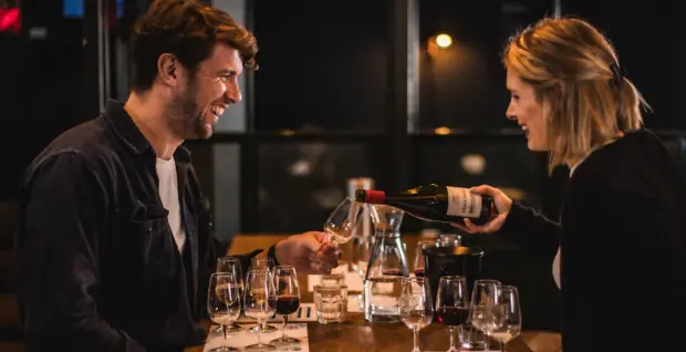 Educator pouring red wine for a guest during a wine masterclass at Vagabond