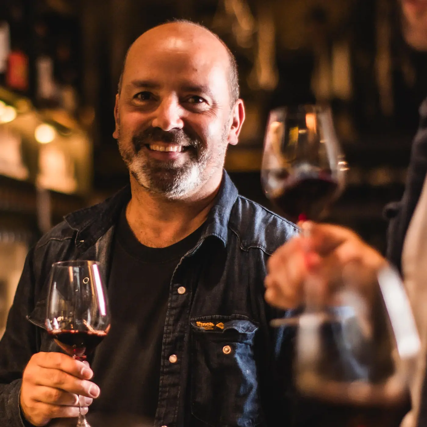 Ben Gubbins, DipWSET and Head of the Vagabond Wine Academy, holding a glass of red wine