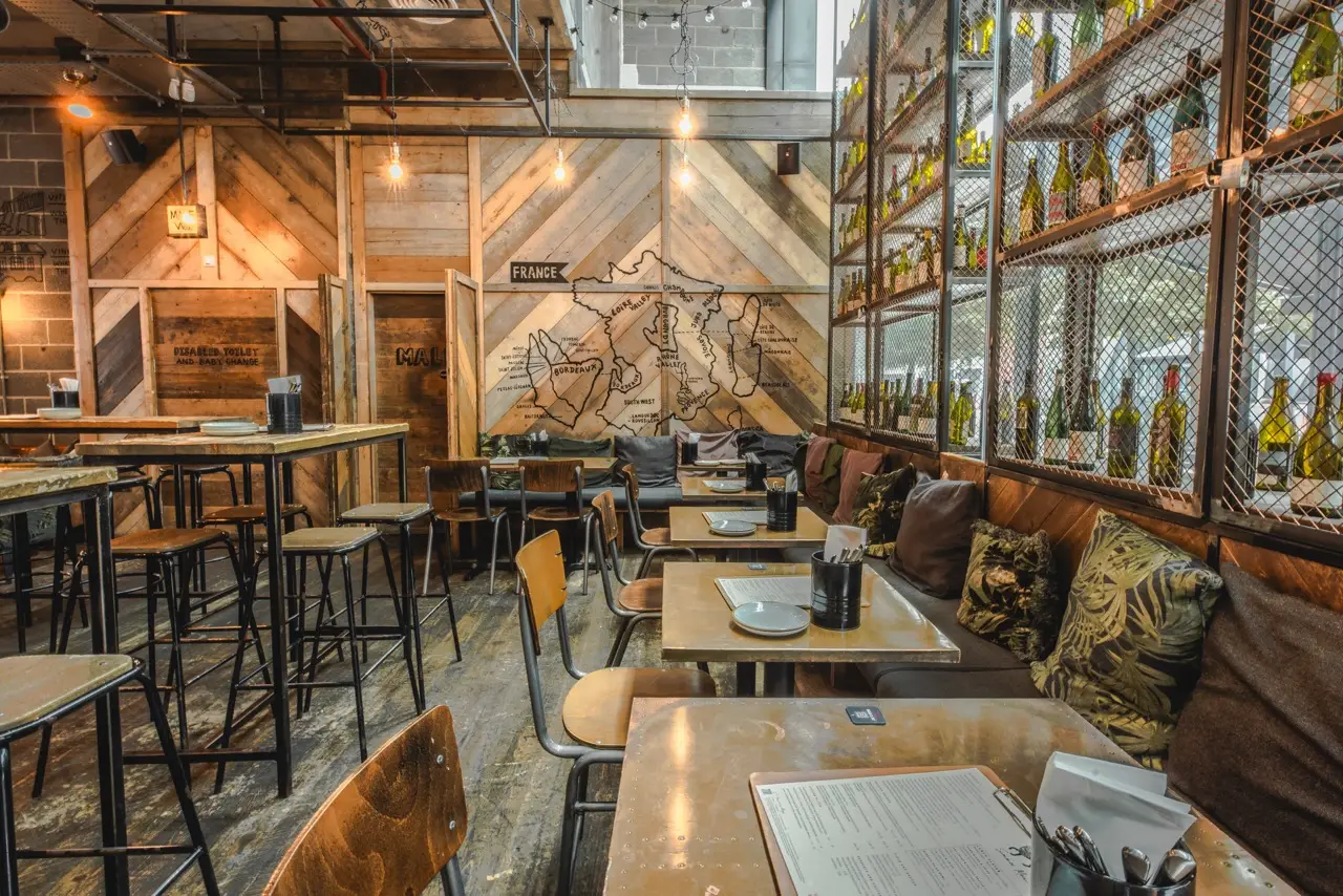 Wood-panelled seating area beneath a map of French wine regions at Vagabond Victoria