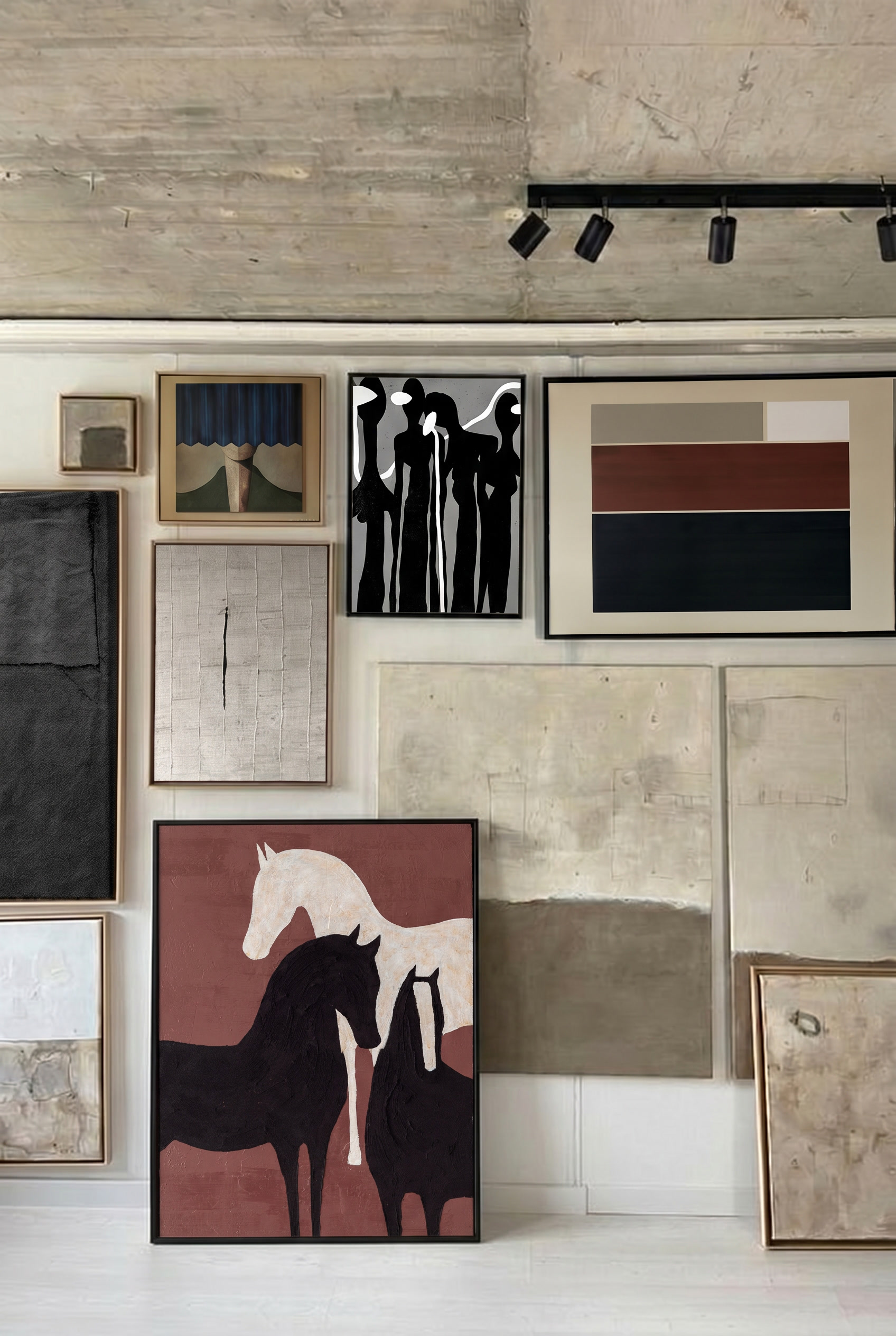 Gallery wall with framed abstract and modern art paintings, including stylized horses, black figures, geometric blocks, and textured neutral canvases.