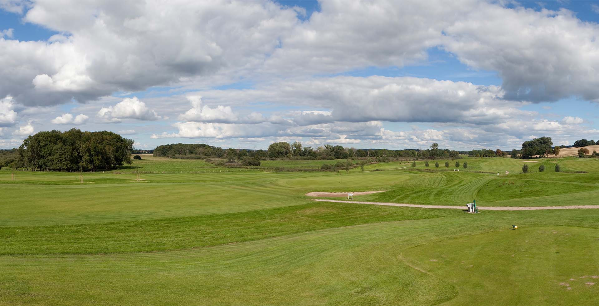 Weite Golflandschaft mit Fairway, Grün und Baumkulisse im Golfclub Schloss Teschow