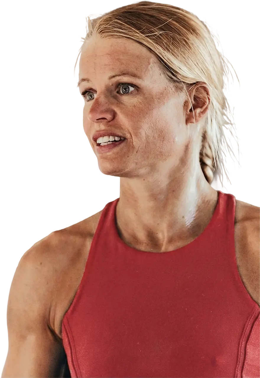Helle Frederiksen in a braid wearing a red sleeveless top, looking to the side.