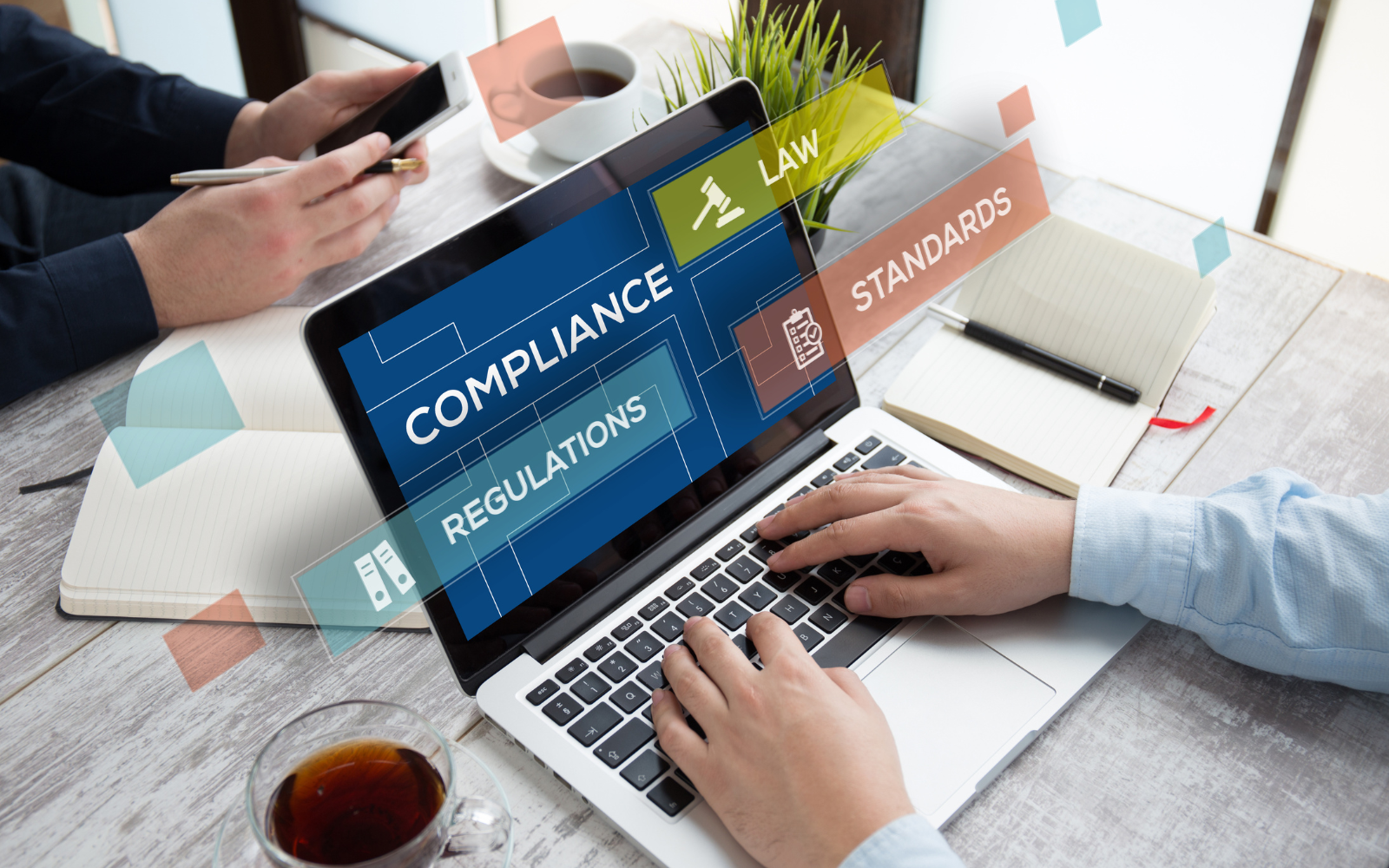 Laptop showing compliance and regulatory information with people working on insurance-related tasks