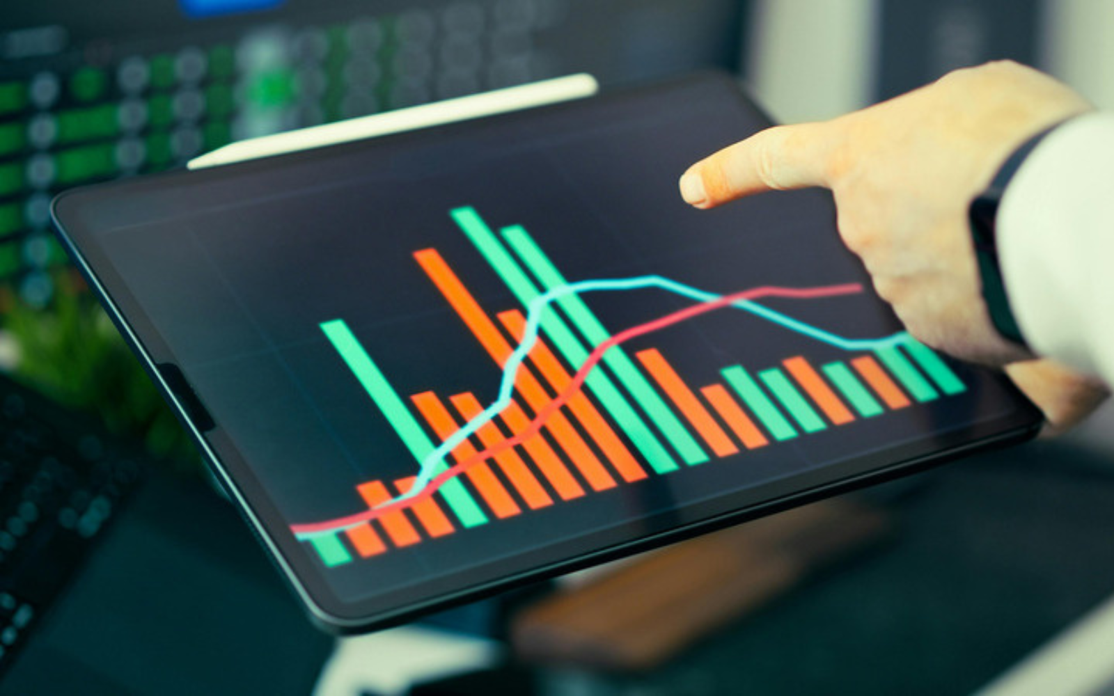 Hand pointing at an analytics dashboard on a tablet showing performance metrics