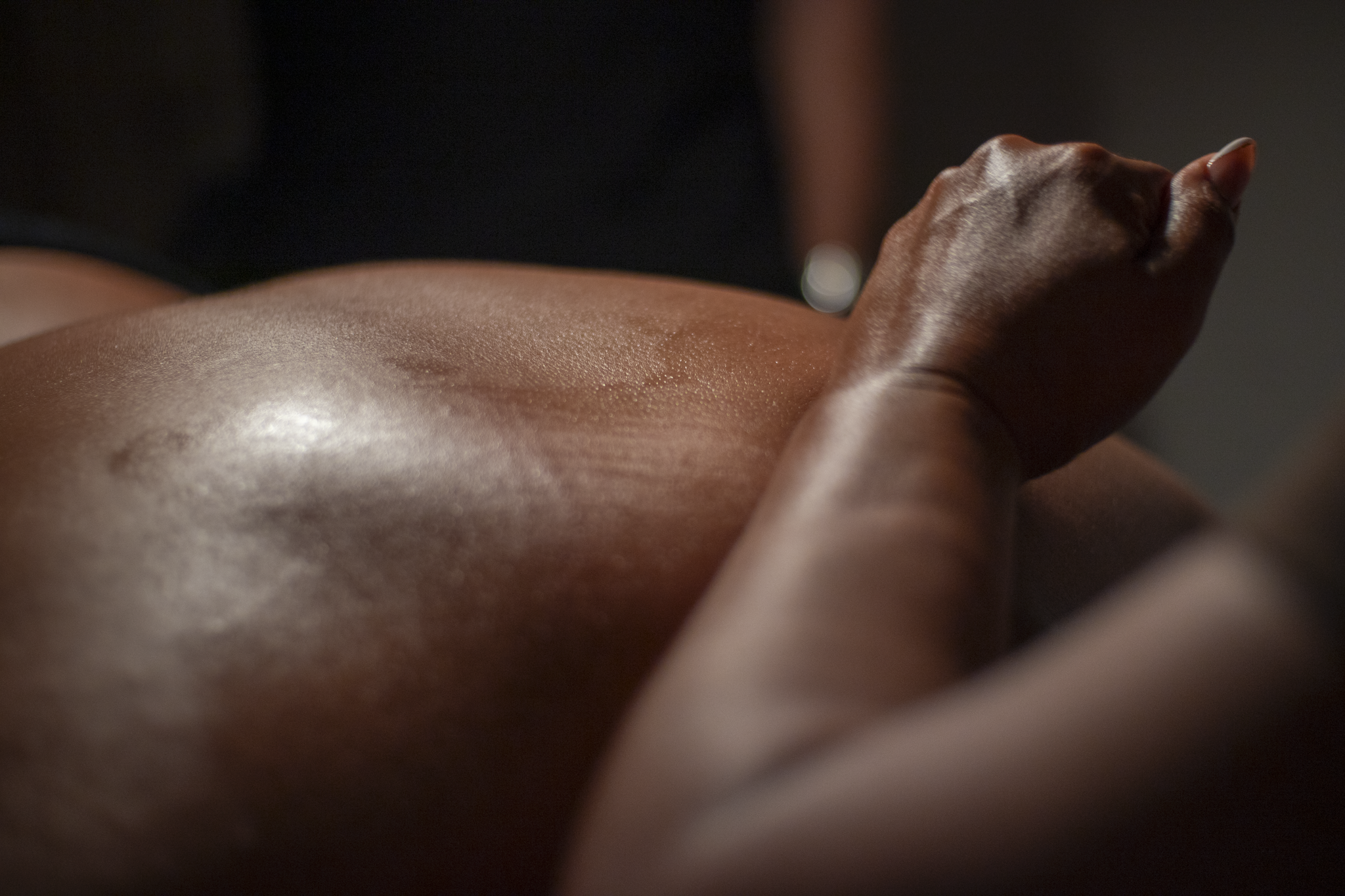 Person receiving a back massage with hands pressing on the lower back.