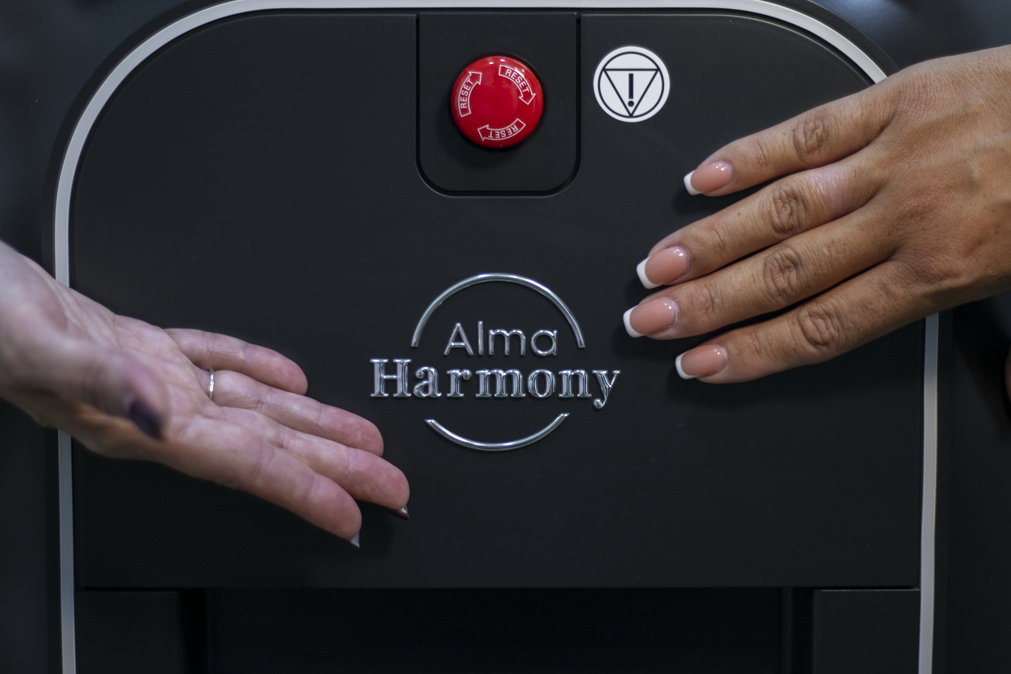 Close-up of hands gently massaging a person’s foot in a calm, softly lit setting.