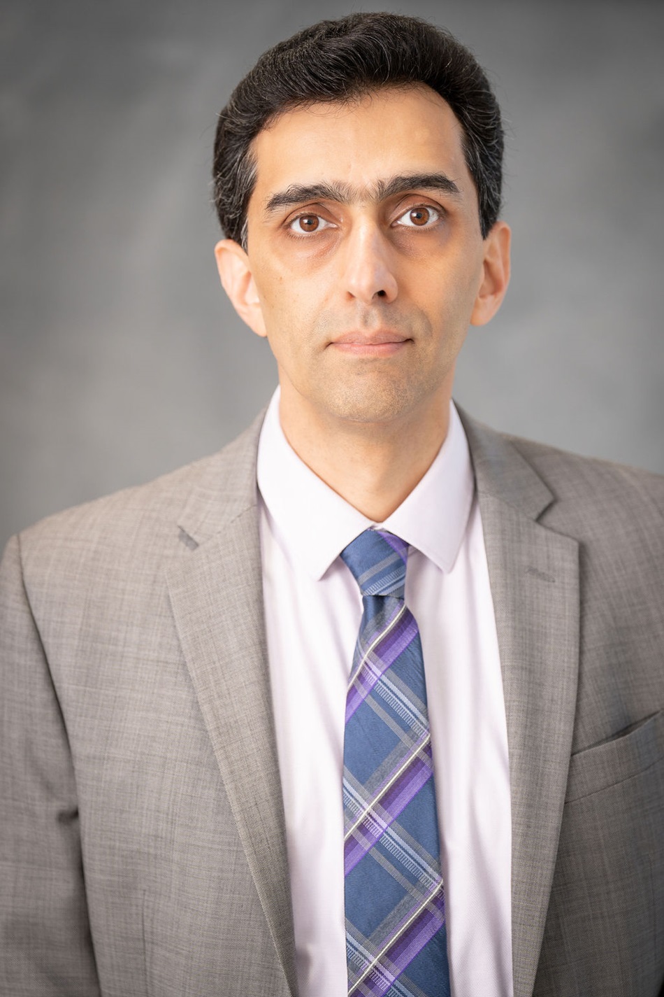 Sam Agdasi close-up portrait with suit and striped necktie