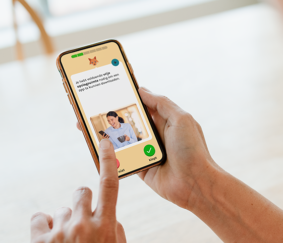 Foto van persoon die smartphone in handen heeft en de DigiHandig app gebruikt. Op het scherm is een vraag over opslagruimte te zien waarop je met klopt niet of met klopt moet antwoorden,