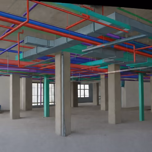 3D BIM model showing color-coded MEP systems including red fire protection, teal HVAC ductwork, and purple electrical conduit coordinated in a commercial building ceiling space