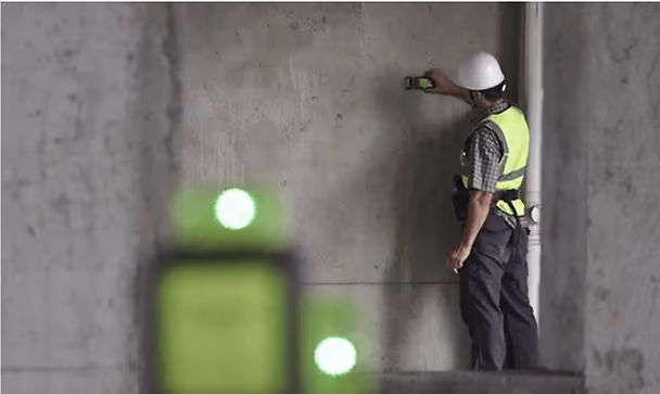 Construction worker using green laser level with detector
