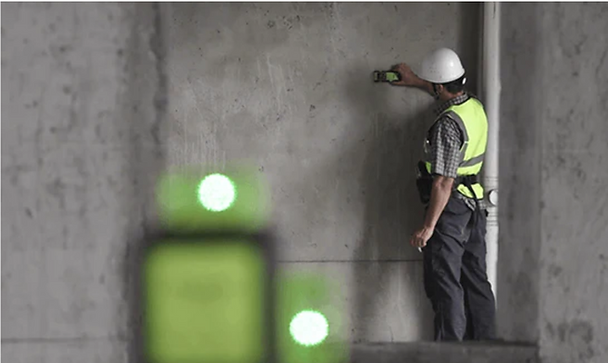 Construction worker using green laser level  with detector