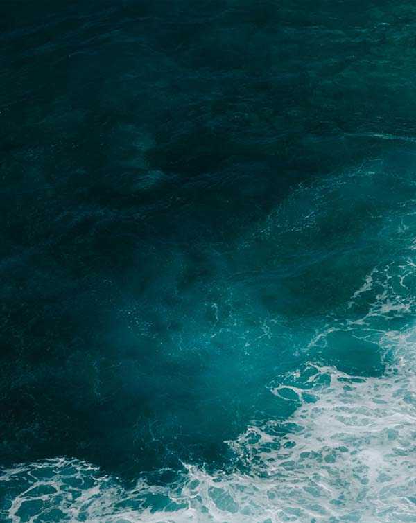 Deep blue ocean water with white foamy waves.