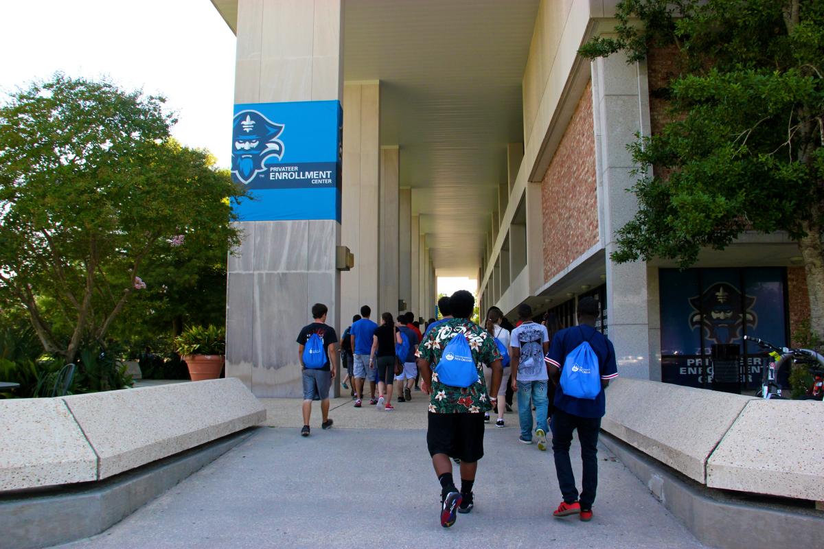 Students walking under Library Breezeway with LSU New Orleans bags 
