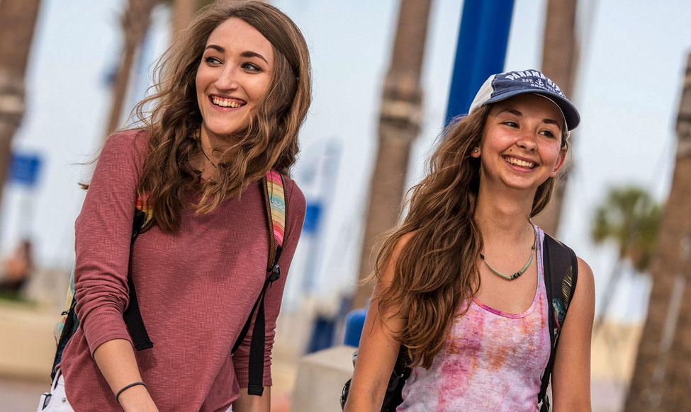 two women smiling on campus