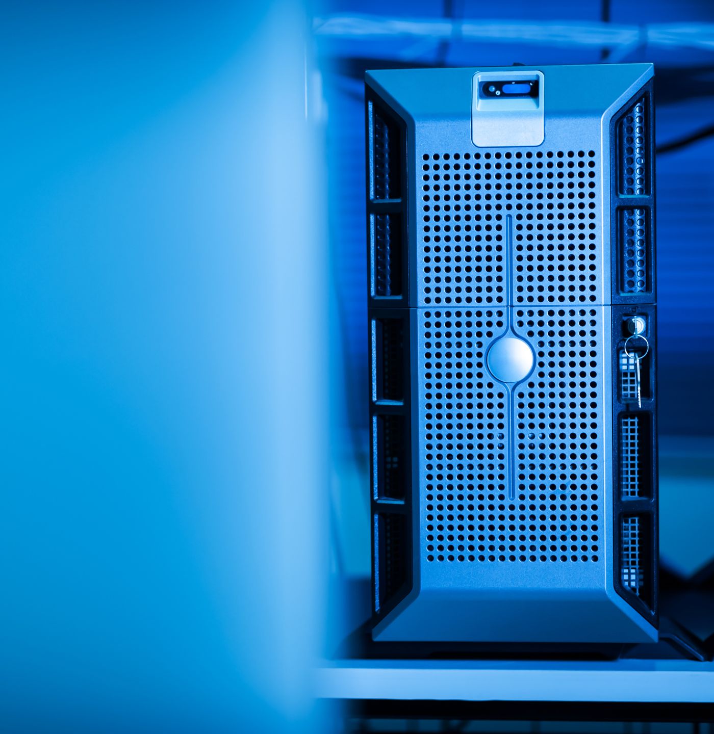 Close-up of a modern server unit with ventilation holes and a key inserted in the lock.