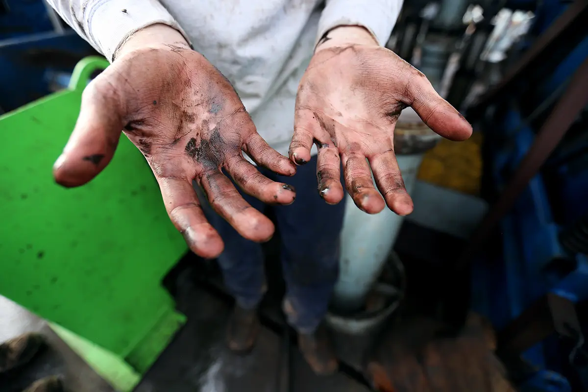 Close up of hands with drilling fluid