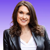 Smiling woman with long brown hair wearing a black leather jacket and white top on a purple background.