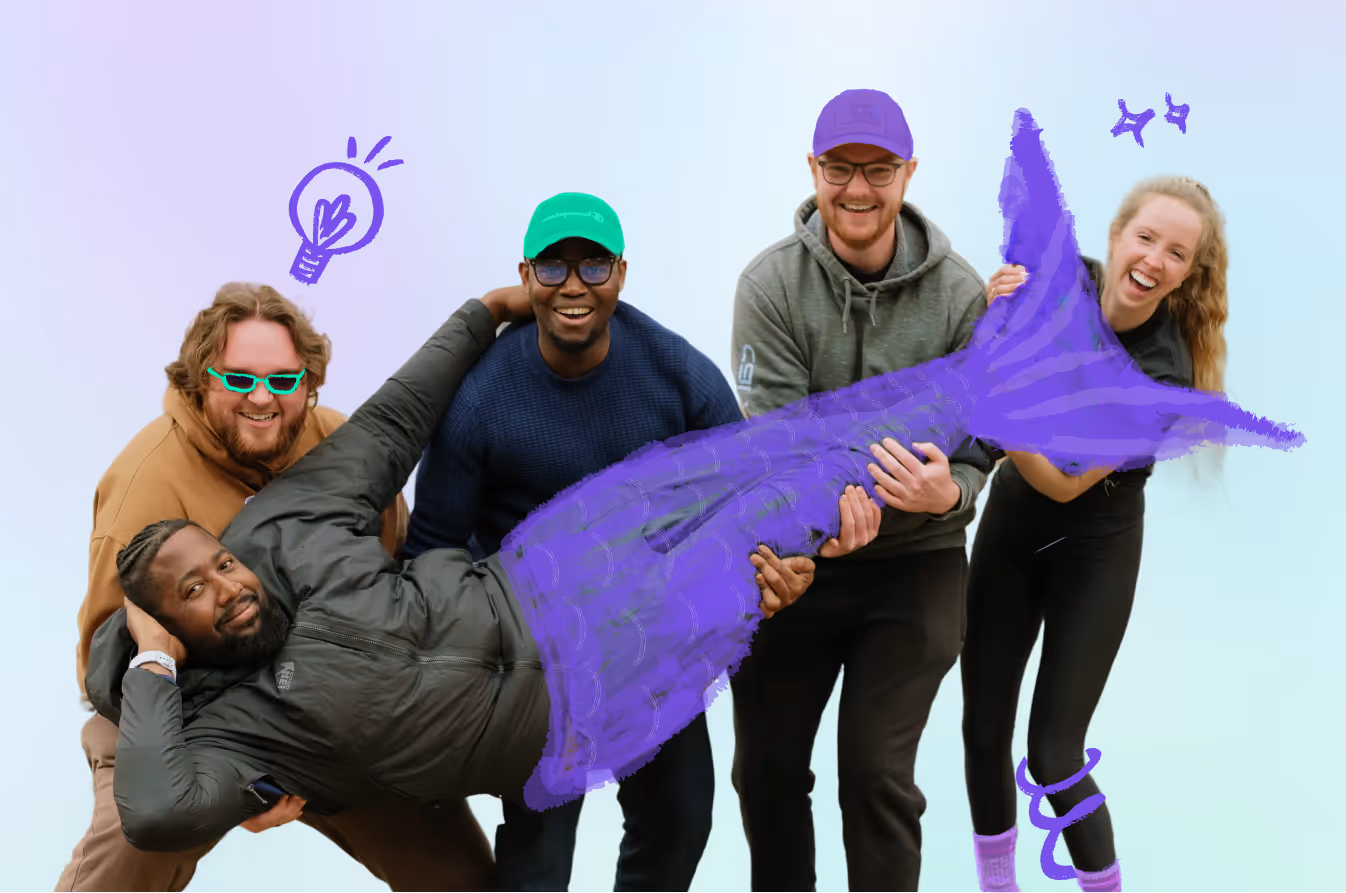 Group of four people holding a man with a digitally drawn purple mermaid tail and doodles.