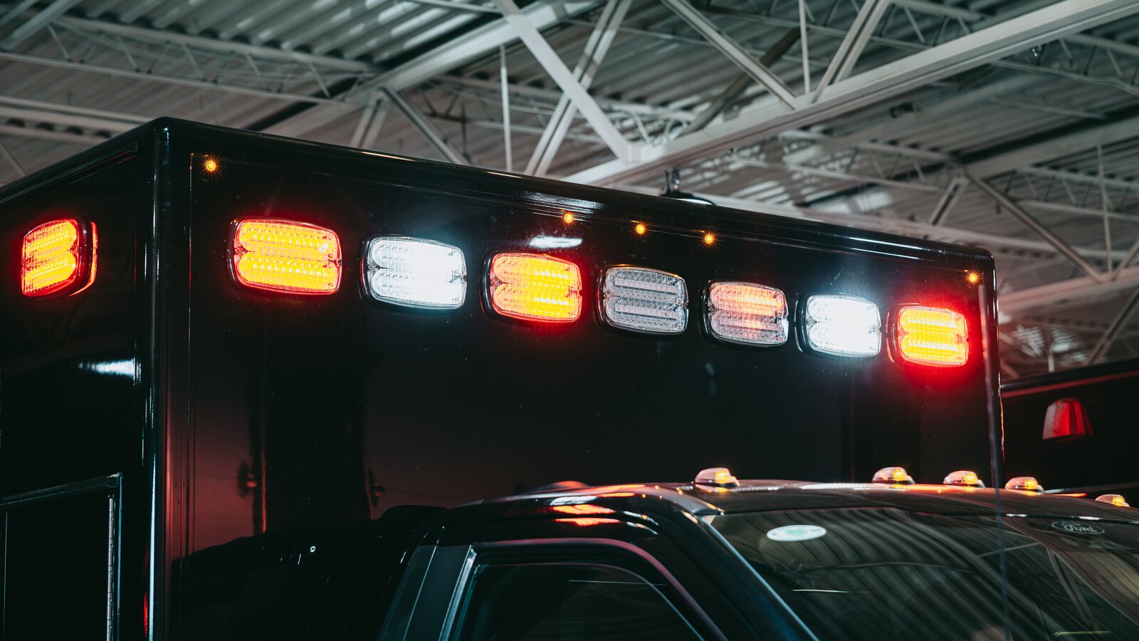 Northwest Rescue ambulance with red emergency lights activated in the station bay, illustrating when to call 911 versus driving to the ER.