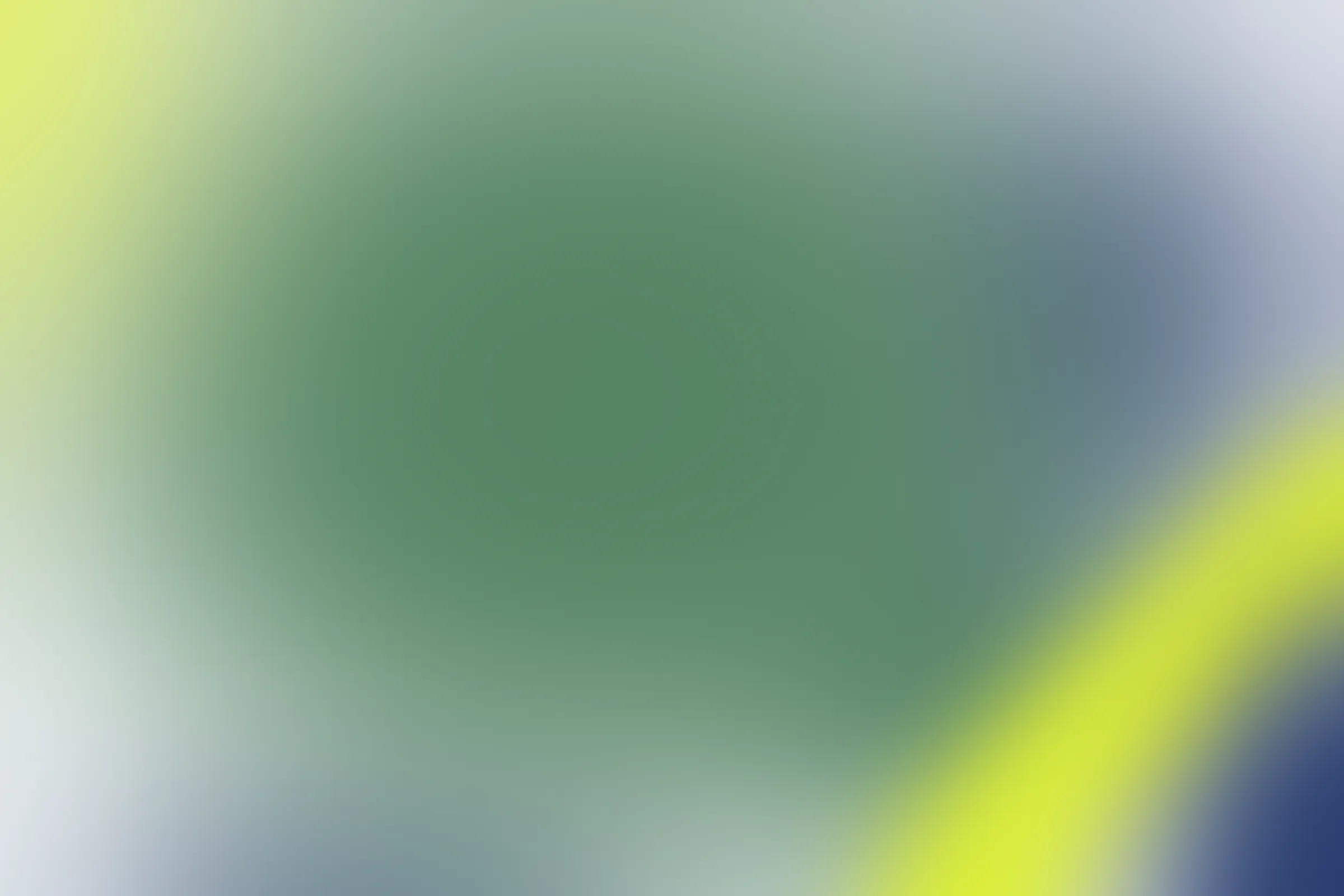 Abstract blurred gradient background blending green, blue, and yellow colors.
