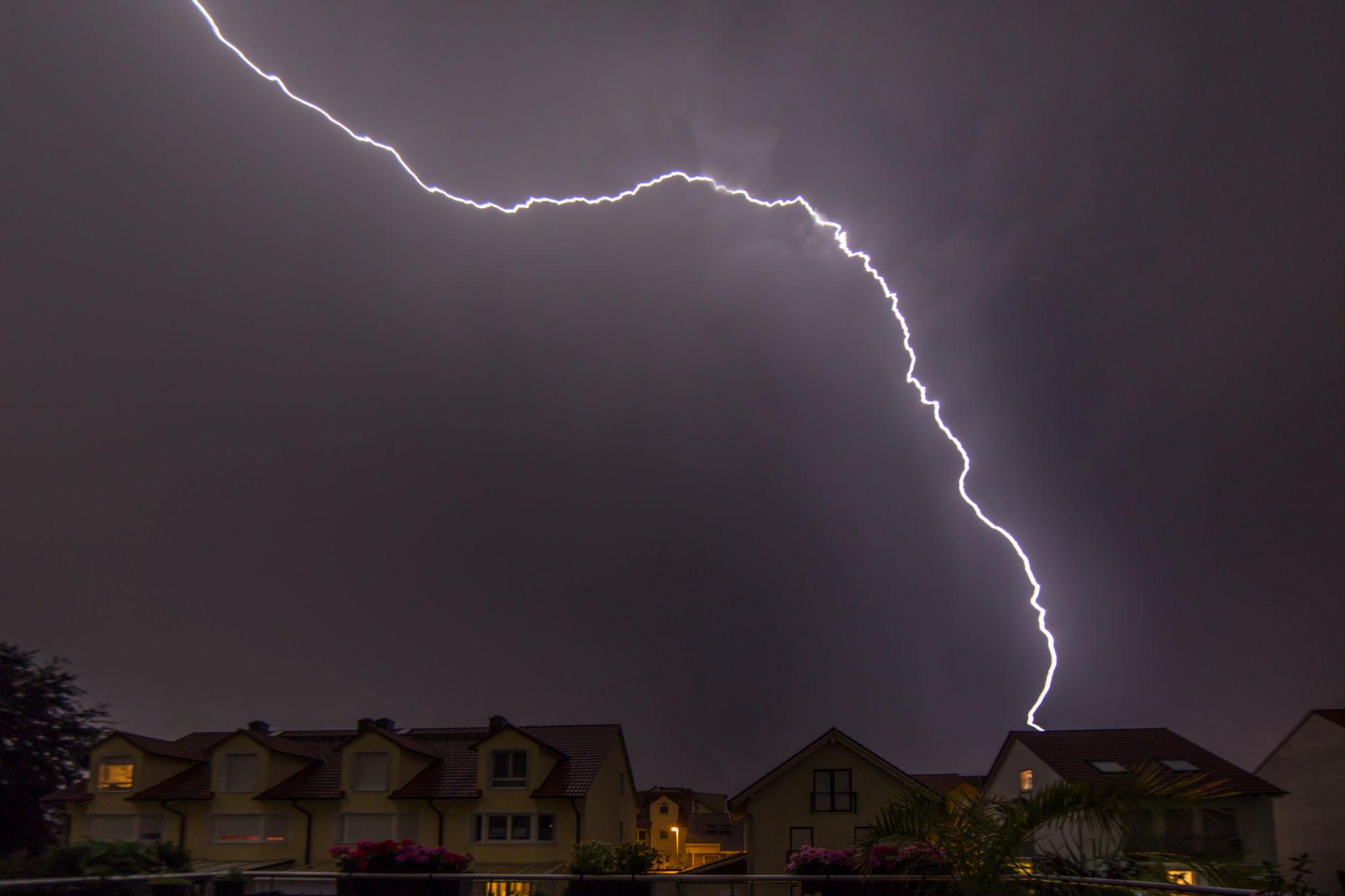 House without lightning protection system hit by lightning bolt at night