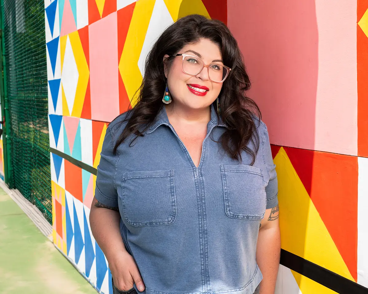 Photo of Olivia Trimble standing in front of a painted wall