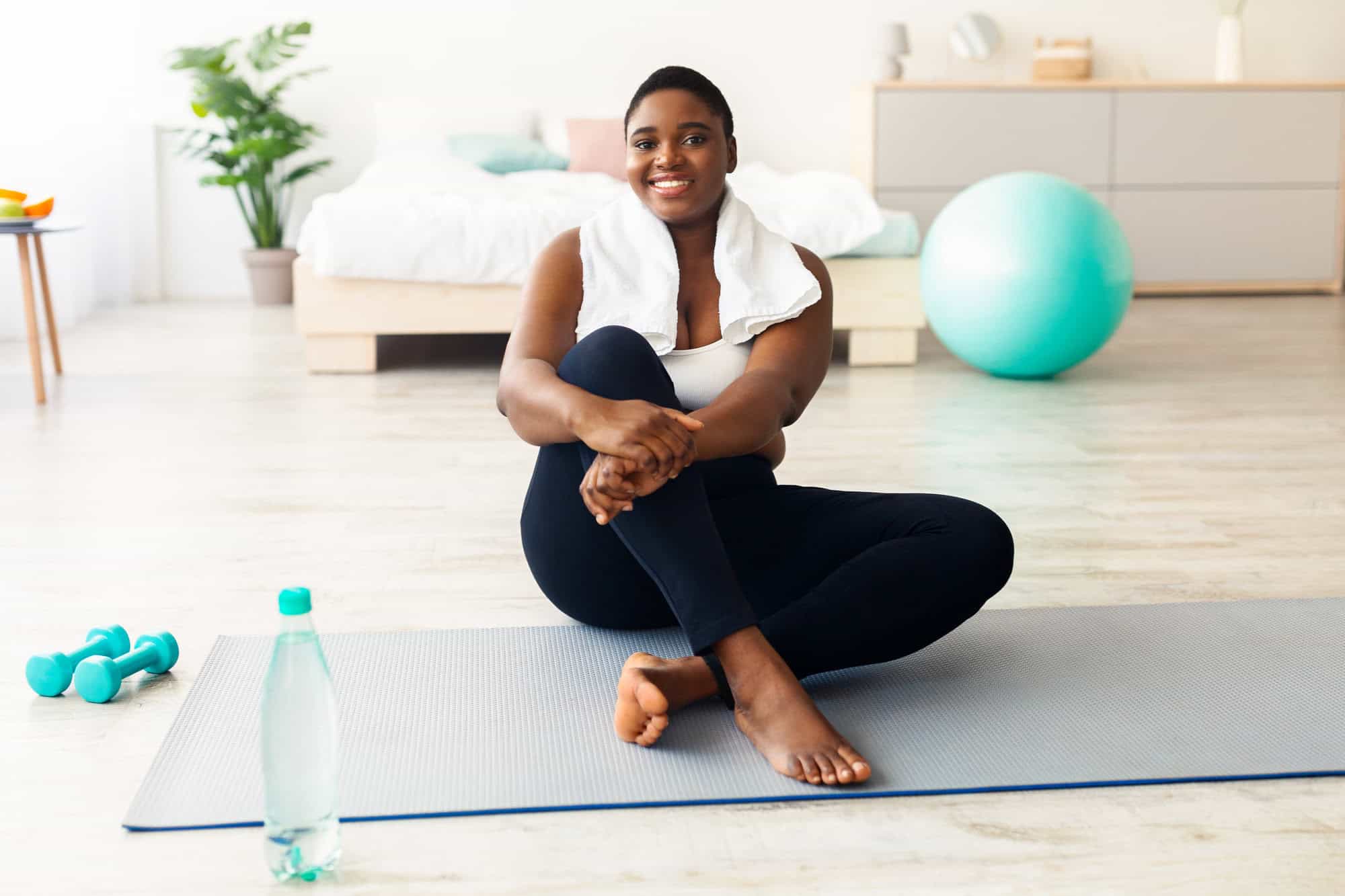 Woman sitting on yoga mat, feeling empowered