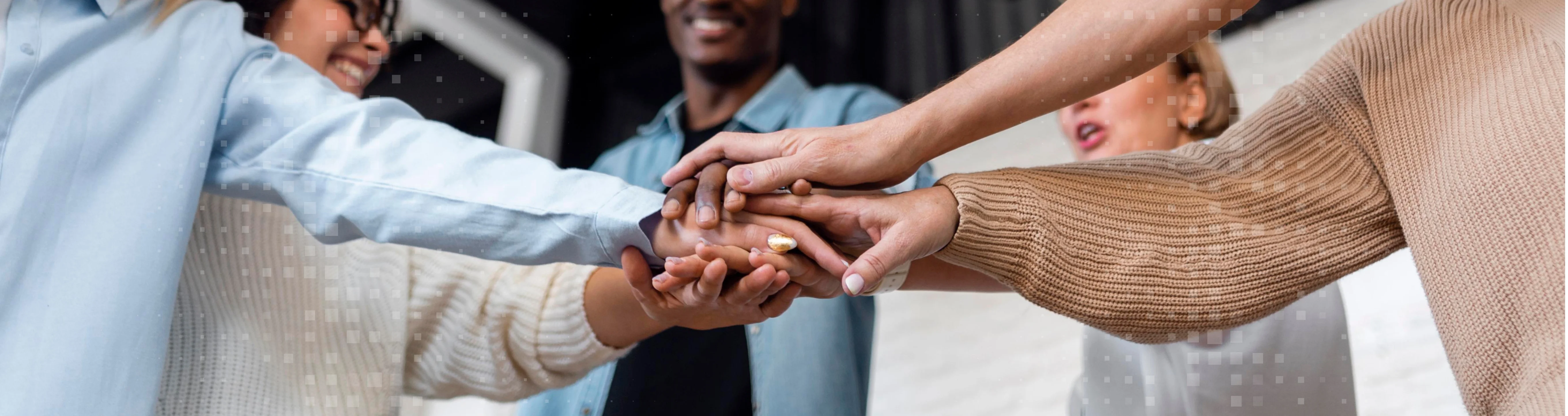 Diverse group of people joining hands together in a team gesture.