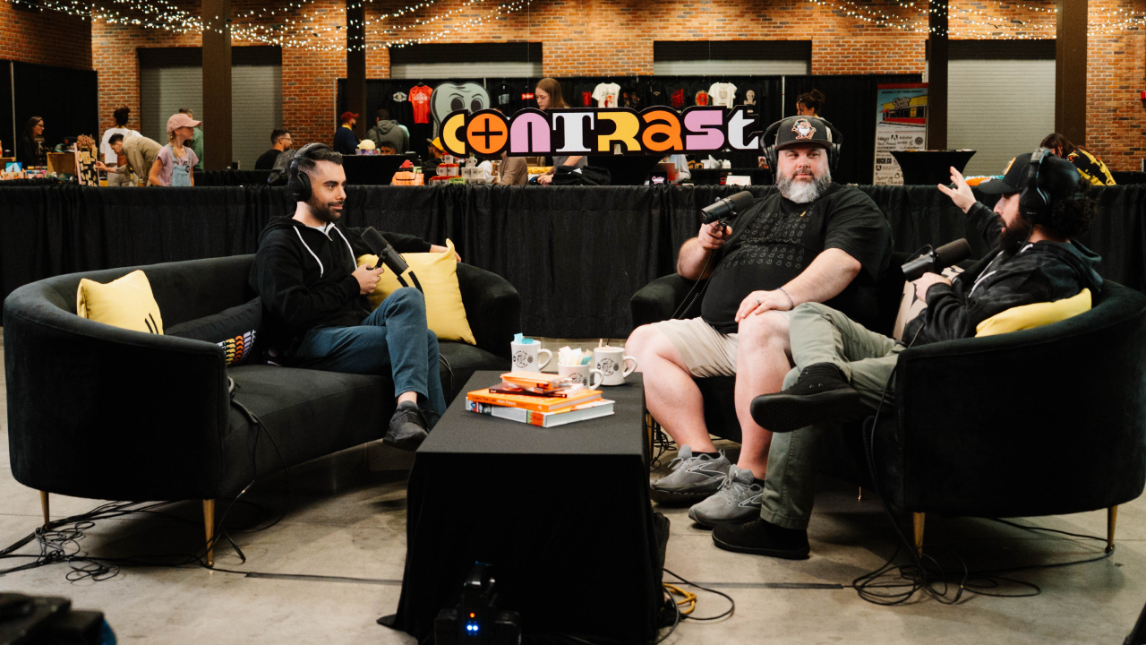 Three men recording a podcast on black couches
