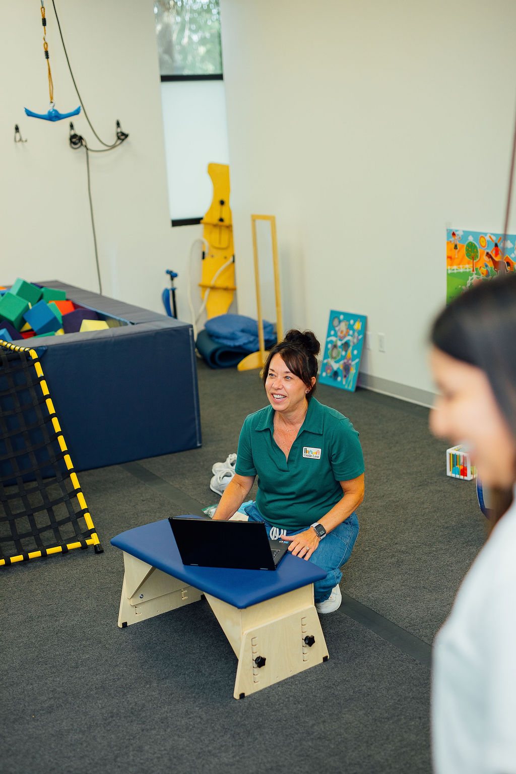 Oaklin Lane therapist taking notes on a laptop in the therapy gym