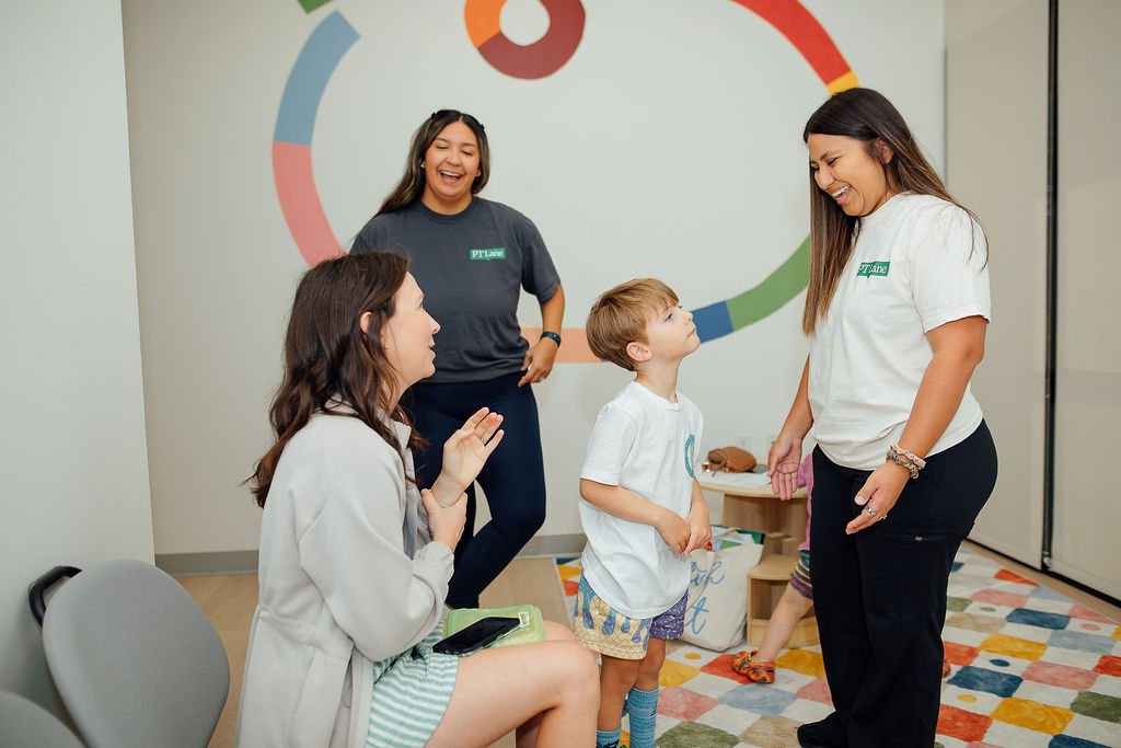 Parent and child talking with two Oaklin Lane therapists at the clinic