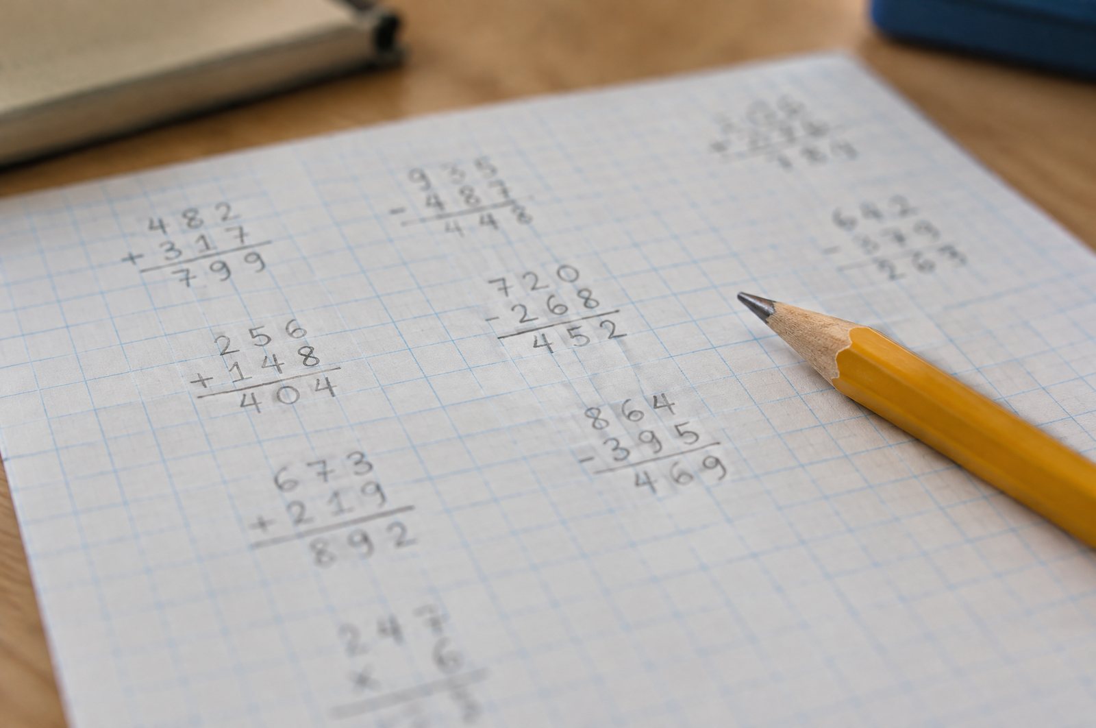 Math worksheet on graph paper with numbers lined up in the grid