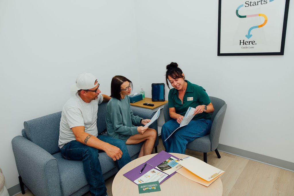 Oaklin Lane therapist reviewing a written plan with parents in a consult room