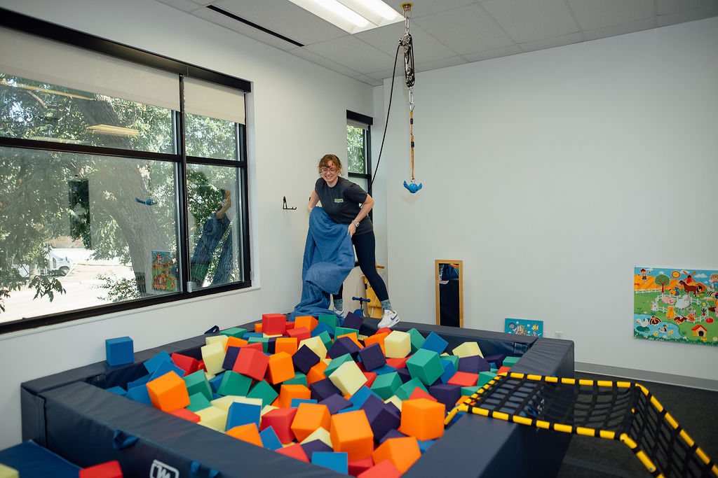 Oaklin Lane therapist preparing the foam pit in the sensory gym