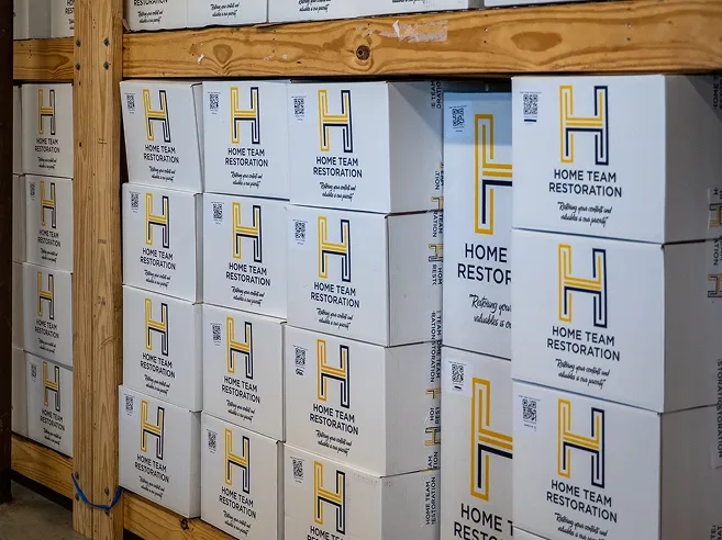 Stacked Home Team Restoration branded boxes in secure contents storage facility in Goldsboro, NC