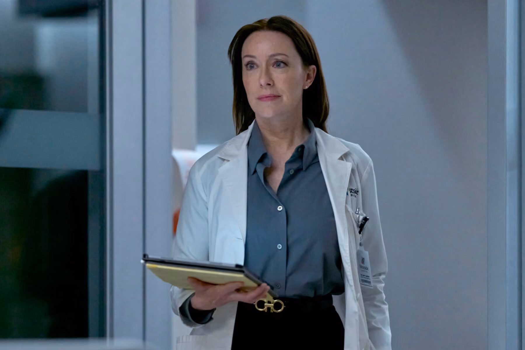 Doctor in a white coat holding a tablet