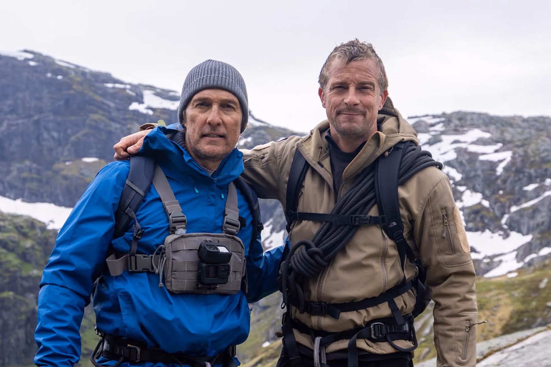 Two adventurers pose on a snowy mountainside
