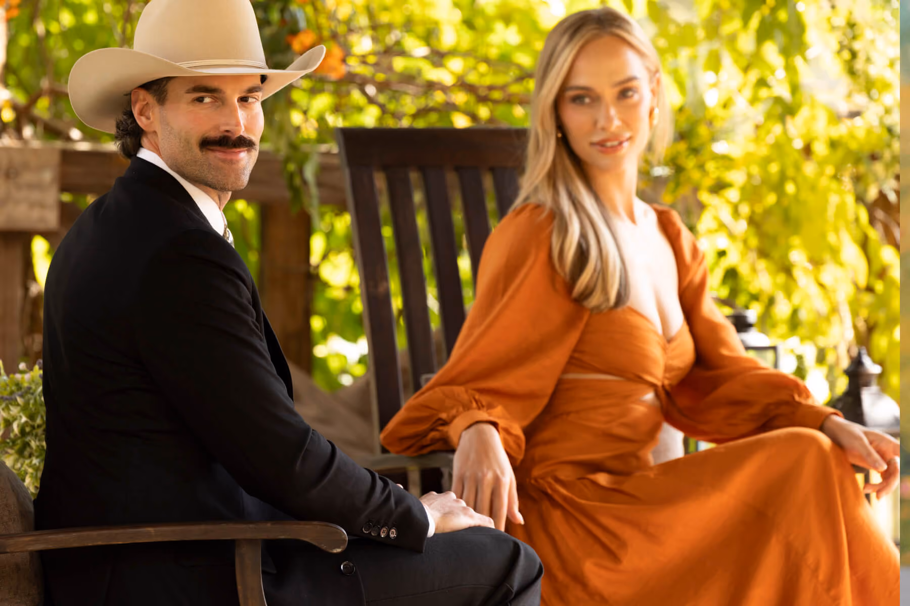 Man in cowboy hat and woman seated outdoors