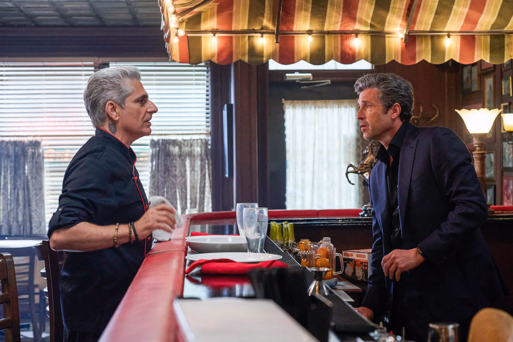 Two men talking across a restaurant bar