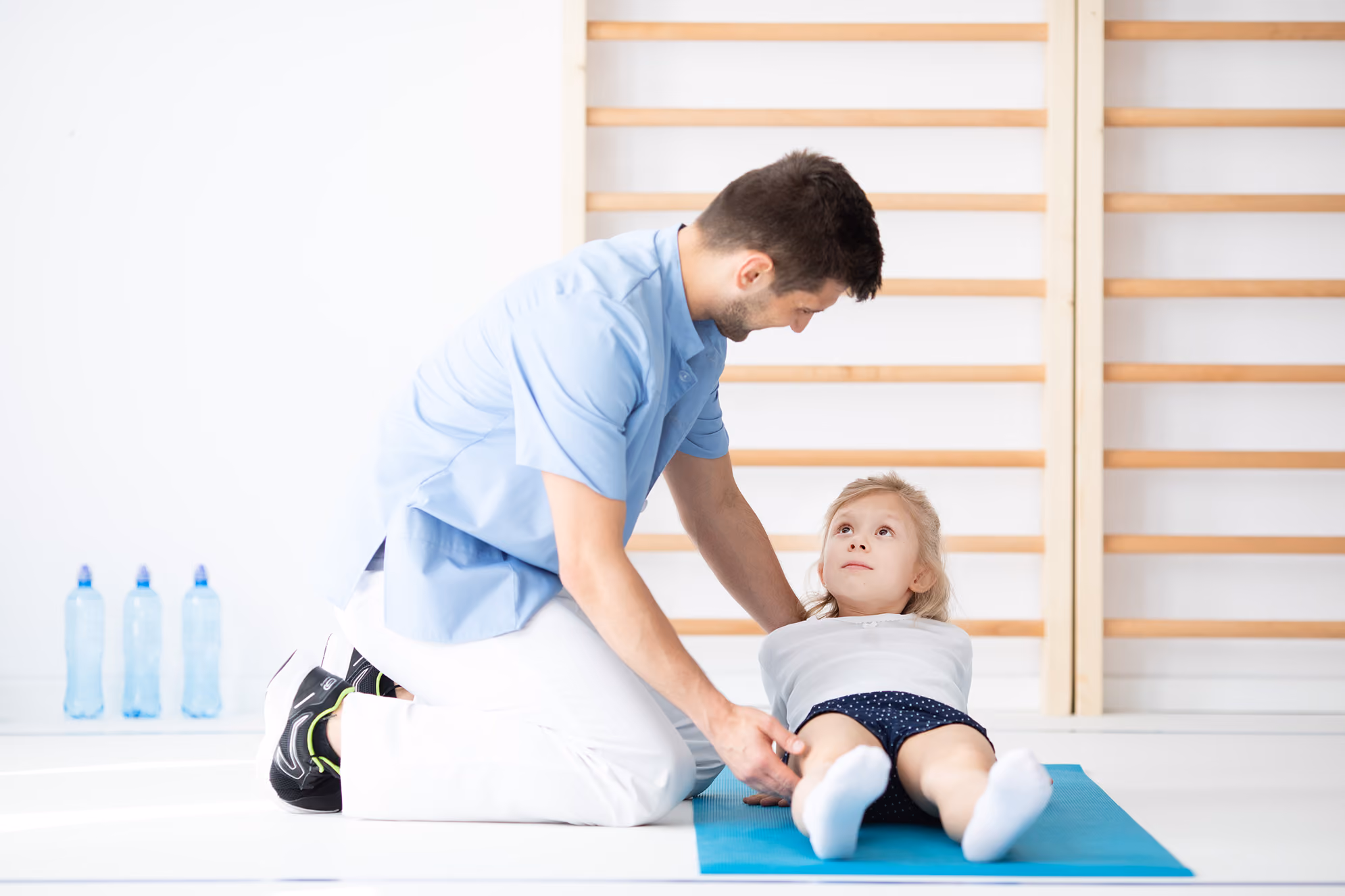 Osteopata Physioss effettua una manovra sul ginocchio di una bimba