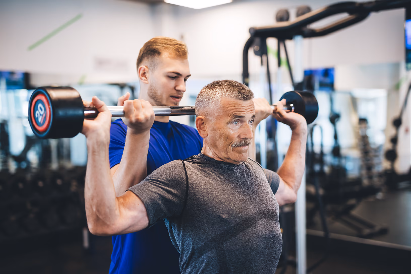 personal trainer Physioss, assiste un signore nel esecuzione di un esercizio