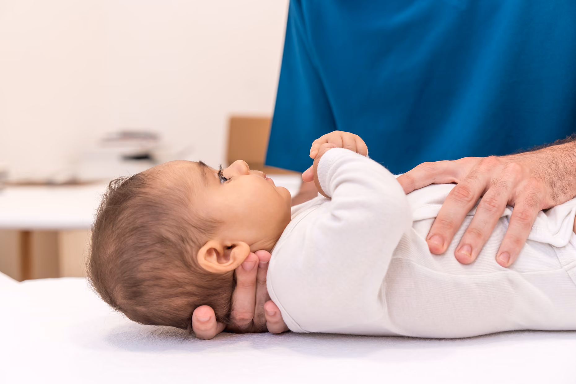 osteopata specializzato in osteopatia pediatrica del centro Physioss di borgaretto effettua un trattamento dolce su un neonato