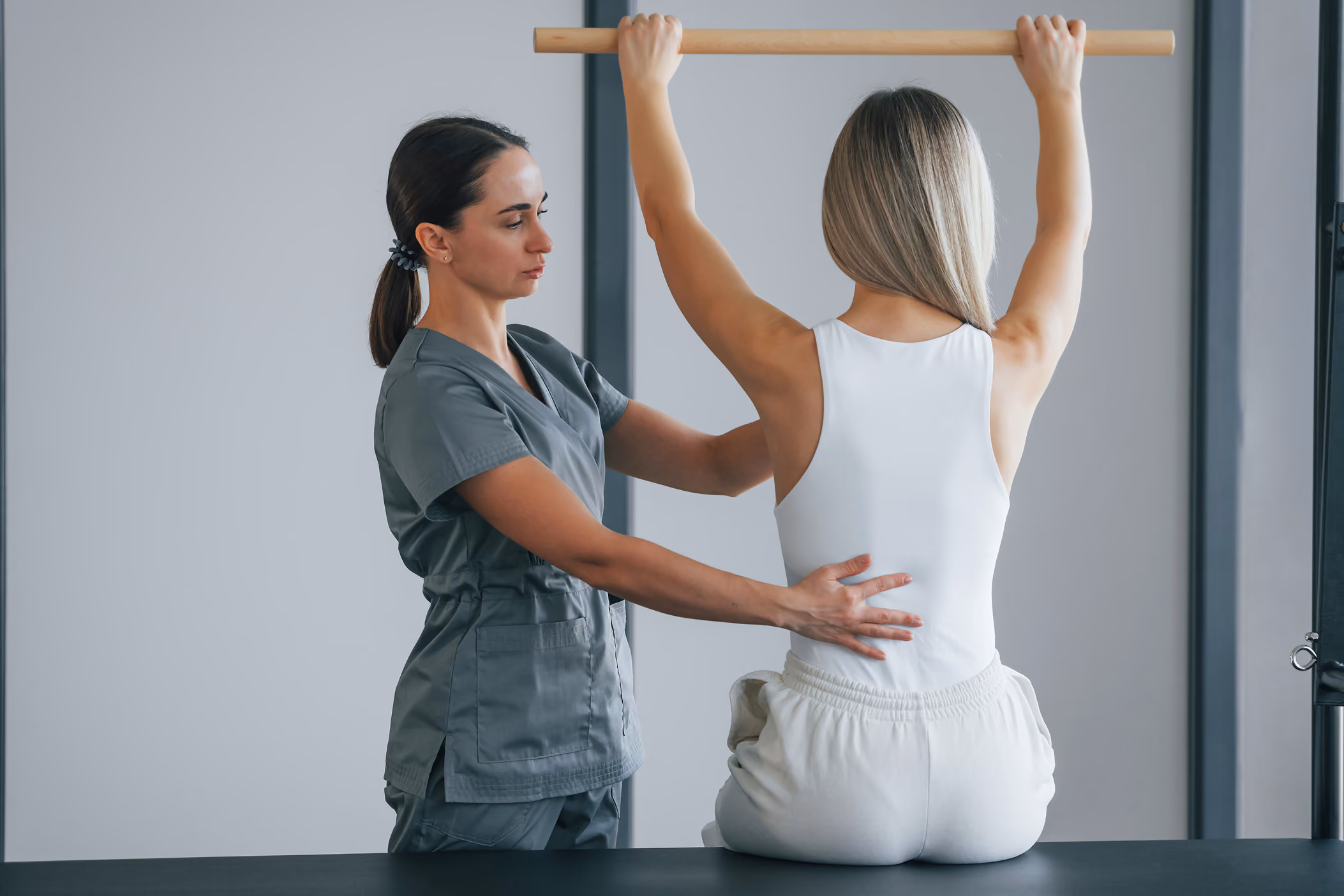 Terapista Physioss assiste la paziente, correggendo la postura.