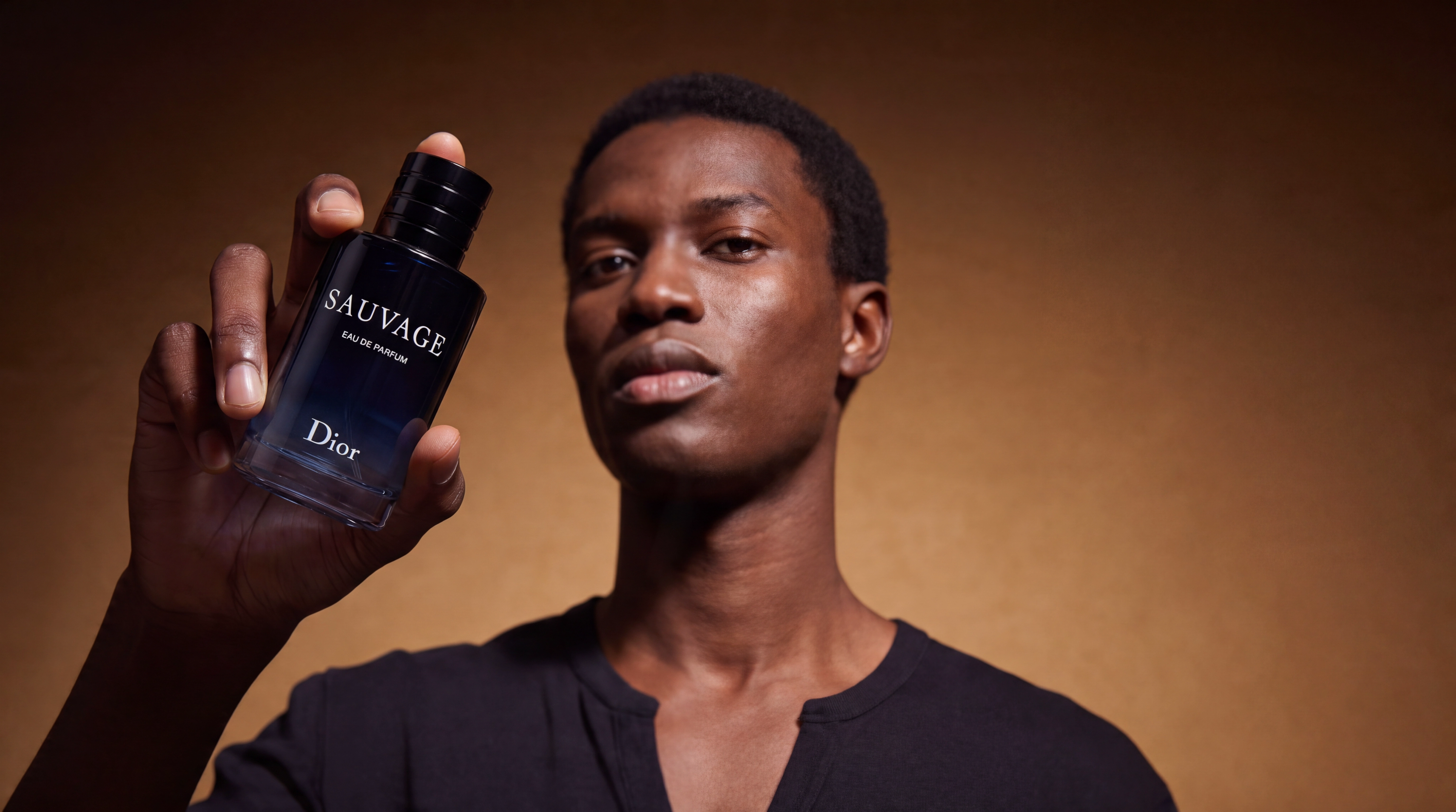 Fotorealistisches männliches KI-Model präsentiert Dior Sauvage Parfüm im Studio, Produktinszenierung, Trickhouse KI-Model-Agentur